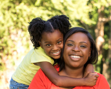 adult woman and female kid smiling