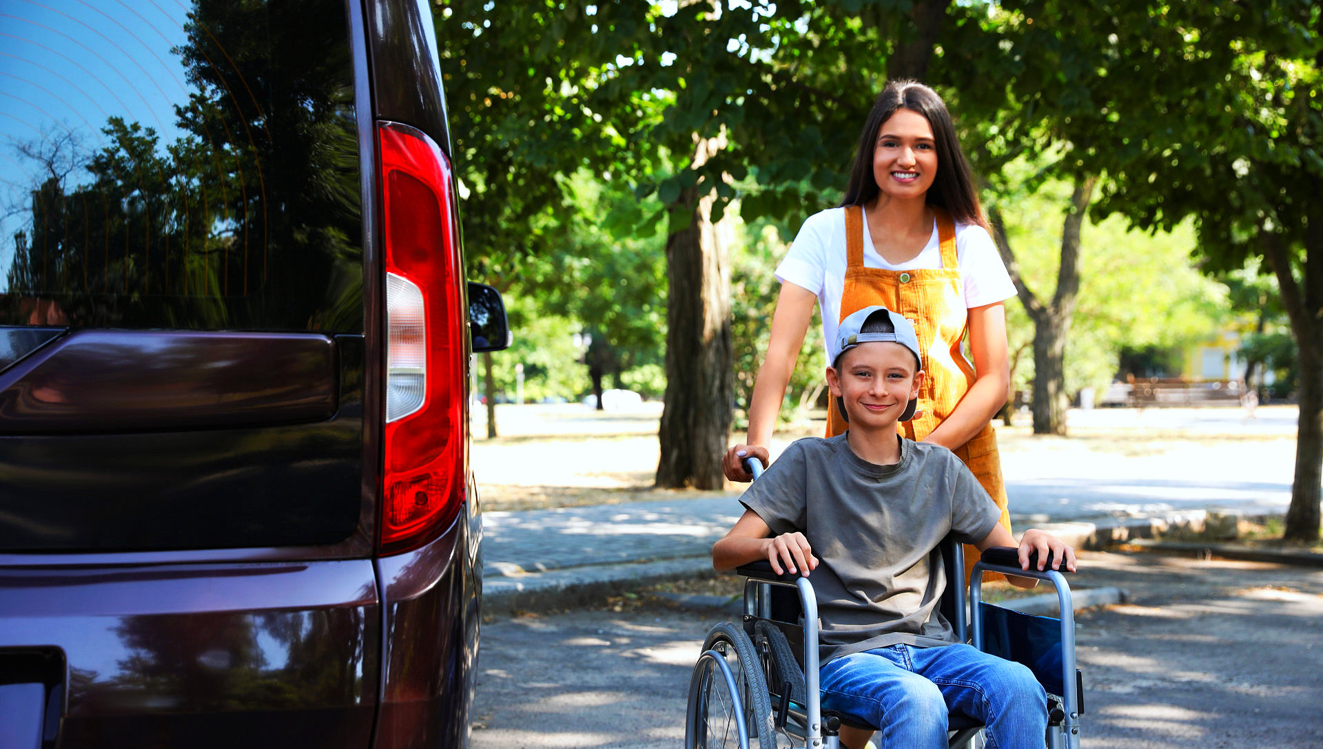 adult woman and kid sitting in the wheelchair smiling