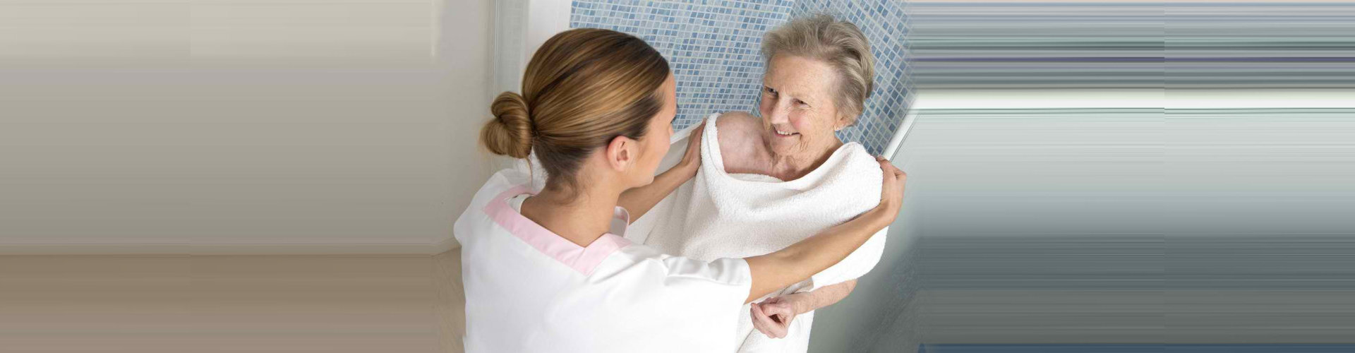 caregiver assisting a senior woman bathing